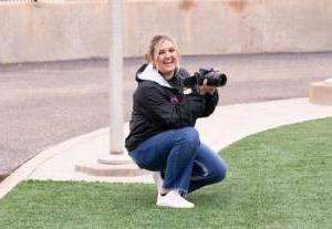 Kacie Eurek with her camera at the football field.